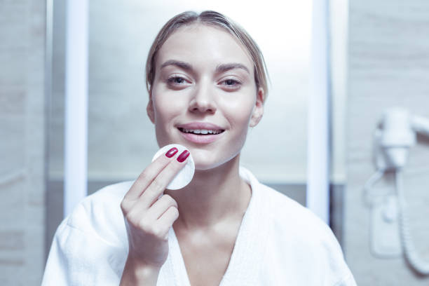 istock Cheerful blonde-haired woman feeling happy removing makeup 1063044576