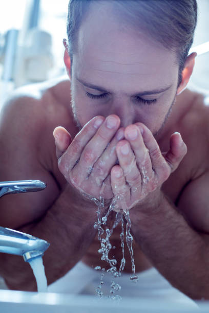 istock Handsome bearded man washing his face after taking shower 1063044652