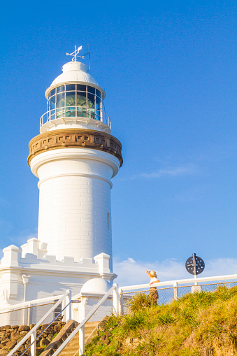 Landscaping of Silent Northeast Atlantic Ocean coast with skyline at low tide with rocks washed up by the surf and real operating Lighthouse at the top of the cliff showing the ships a safe way to go