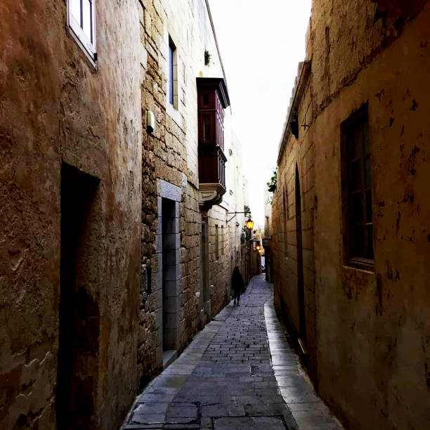 Old, narrow street of the European city in the evening. When street lights come on