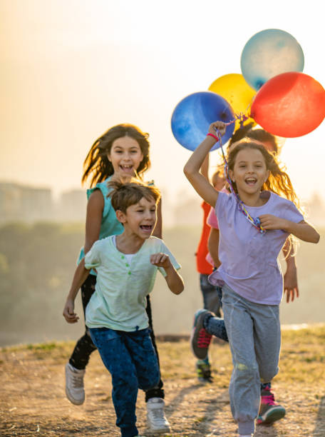 gruppe der kinder mit luftballons - child balloon happiness cheerful stock-fotos und bilder