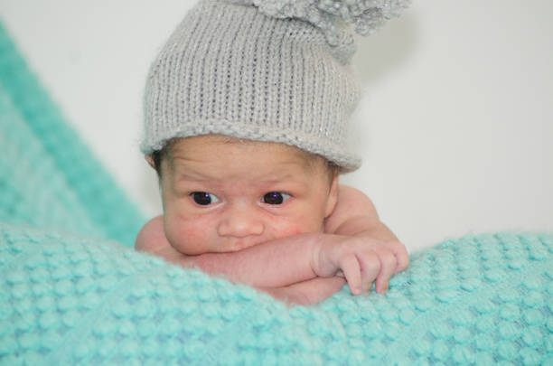4 tygodnie stary nowo narodzony chłopiec z szarym kapeluszem na zielonym kocu - one week old zdjęcia i obrazy z banku zdjęć