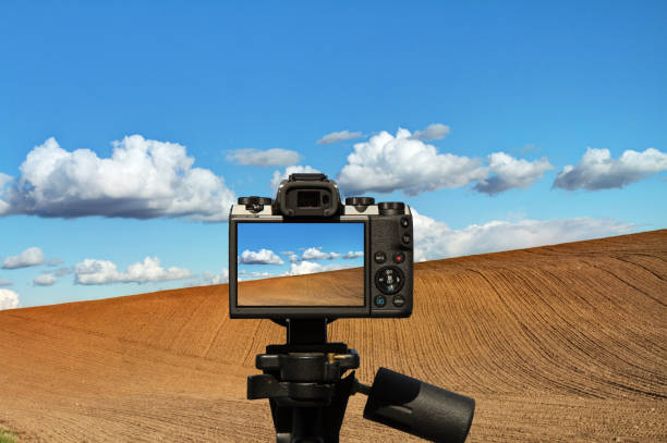 istock camera and plowed field and blue sky 1063058246