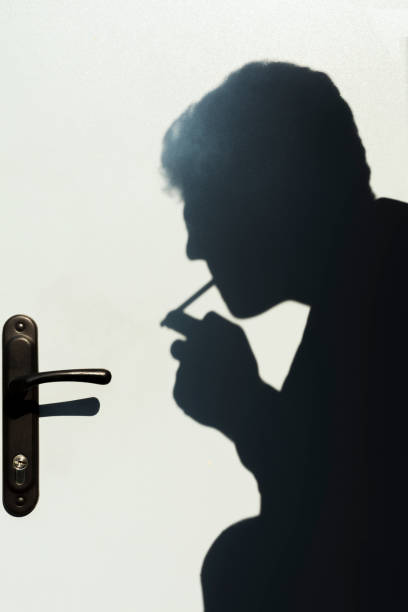 istock shadow of smoking man, young man smoking a cigarette, concept abstract background 1063058430