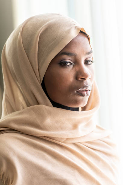 istock Concerned black muslim woman looking through a window 1063060286