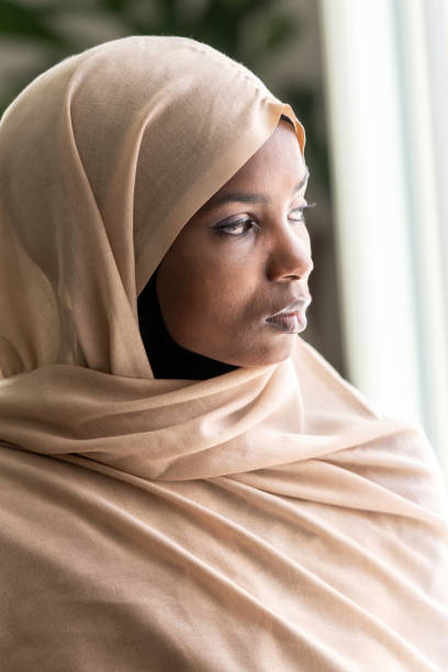 istock Concerned black muslim woman looking through a window 1063060544