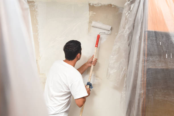 istock Man painting wall at home with painting roller 1063063378