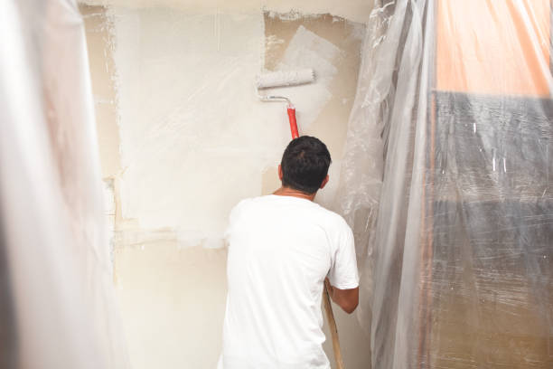istock Man painting wall at home with painting roller 1063064886