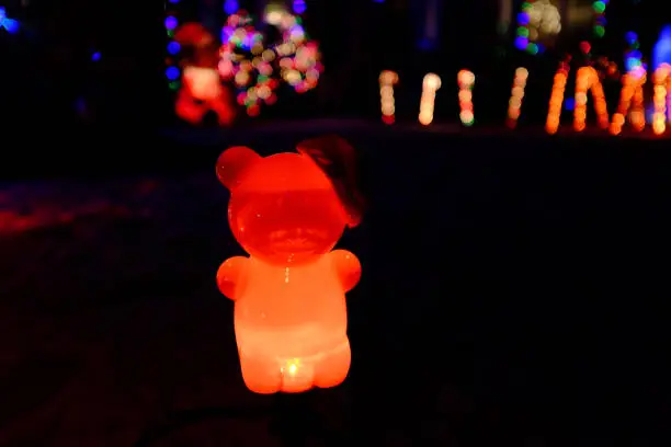 Photo of Vintage Teddy Bear light with red glow with illumination from Christmas lights in the background.