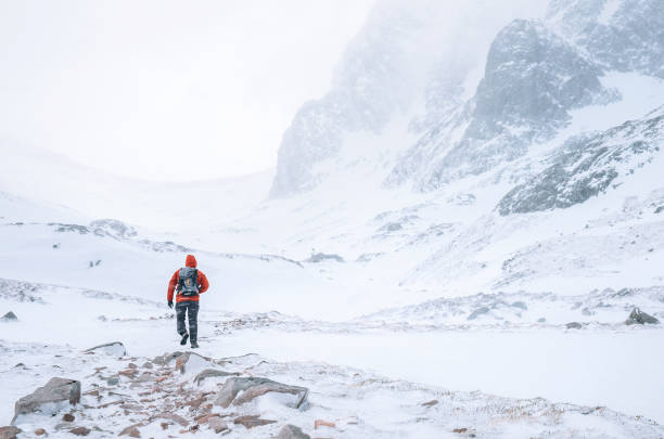 istock Climber walks alone in high mountains at windy snowy weather 1063077198