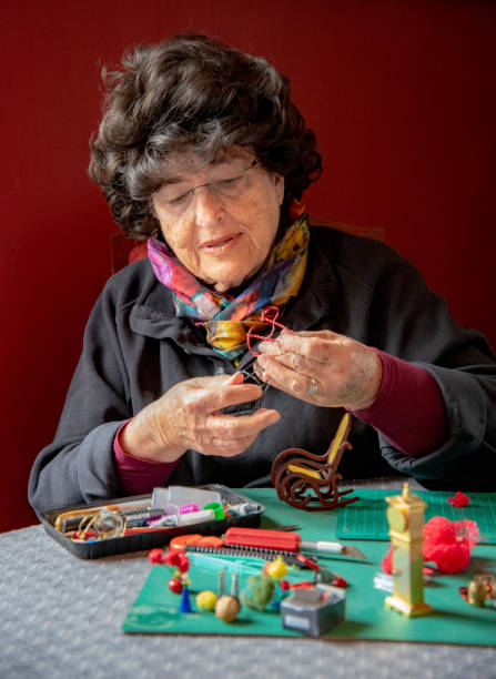 istock Mature woman making miniatures by window light. 1063079314