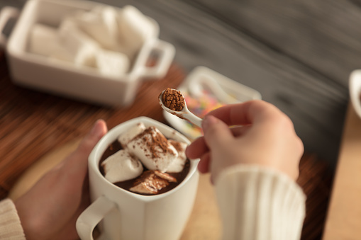 Decorating Hot Chocolate With Cinnamon And Cocoa Powder Using A Tiny Spoon. NOTE: Shallow Depth Of Field