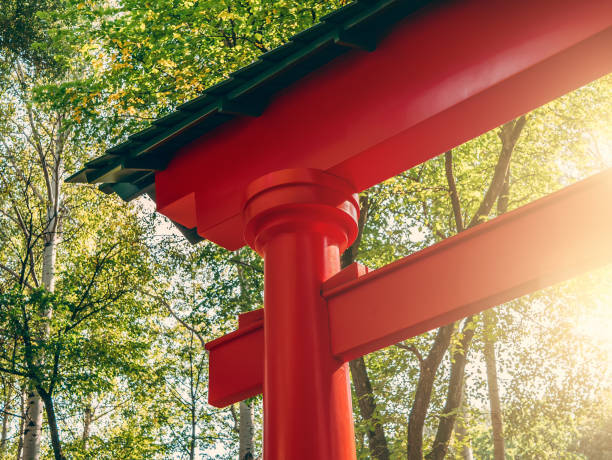 istock Red Japanese gate in sun light at green trees background 1063090334
