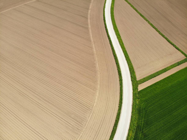 istock AERIAL: Spectacular empty country road winding past vast fields and grasslands. 1063095920