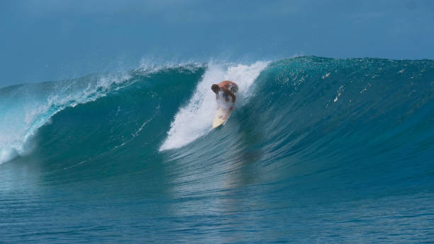 istock CLOSE UP: Pro male surfer stands up on his surfboard and catches a big wave. 1063096168