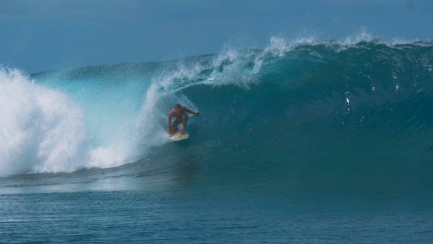 istock CLOSE UP: Pro extreme surfer rides a breathtaking emerald wave in sunny Tahiti. 1063096184