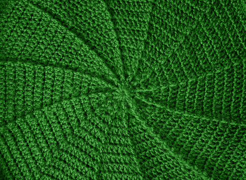 handmade spiral knitting of green wool by handmade crocheting around beret