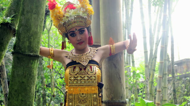 Young Balinese dancer performing Barong dance in a bamboo forest