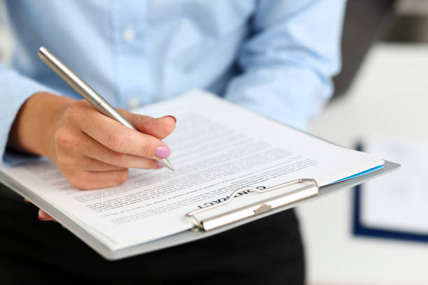 istock Female arm in suit hold silver pen and pad 1063104618