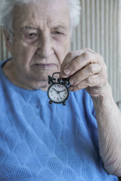 istock senior woman holding a clock 1063115944