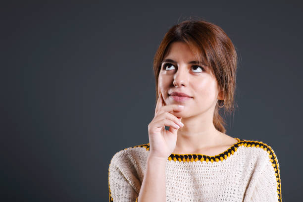 Young woman dreaming on gray background.