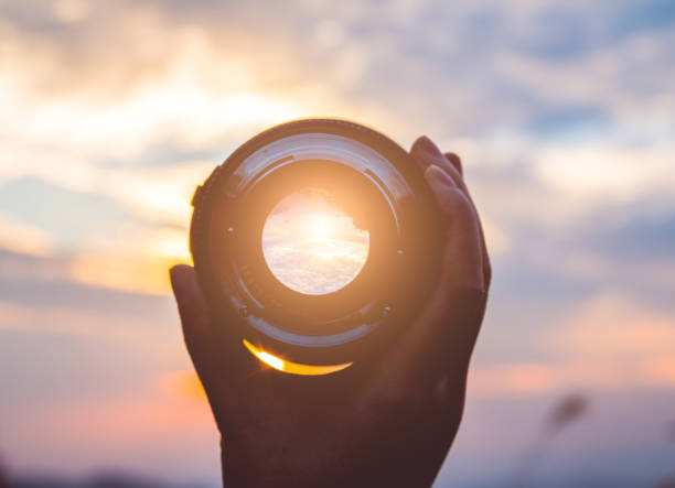 istock Hand holding camera lens at sunset 1063143944