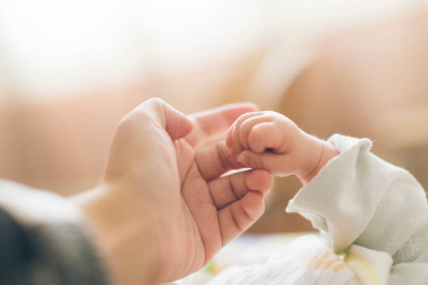 生まれたばかりの赤ちゃんの指の写真 - 母親 ストックフォトと画像