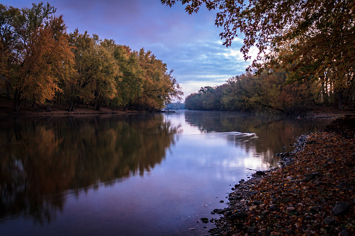 A peaceful morning shortly after daybreak along the banks of Michigan's Grand River in autumn. Natural beauty background with copy space.