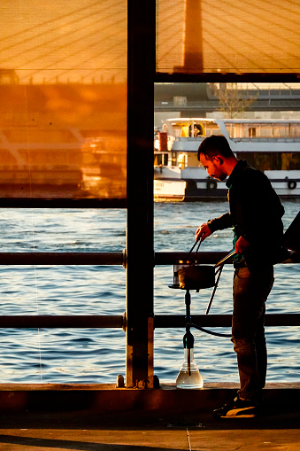 Istanbul, Turkey October 30, 2018 A man prepares a hookah pipe on the Galata Bridge