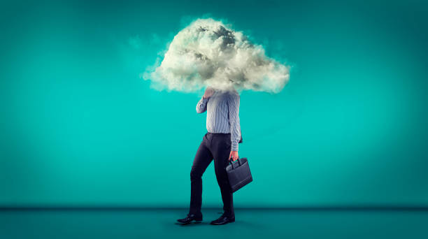 istock Businessman walking on a blue background with a his head in a cloud. 1063169838