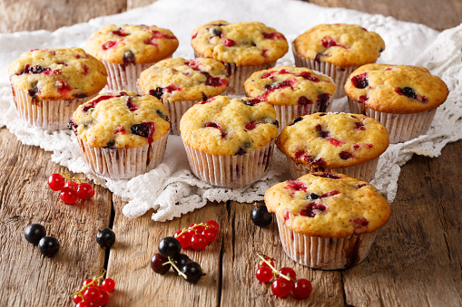Freshly baked muffins with black and red currant berries close-up on the table. horizontal