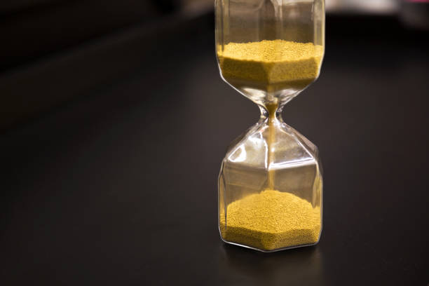 istock Hourglass on rustic wooden table. Time running out or deadline concept. Closeup 1063199614
