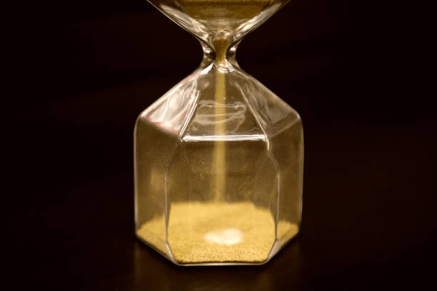 istock Hourglass on rustic wooden table. Time running out or deadline concept. Closeup 1063199628