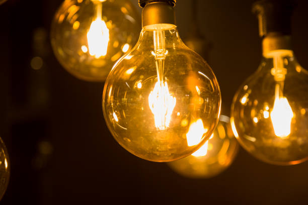 istock Cozy warm yellow light. Edison light bulb hanging. Closeup 1063199734