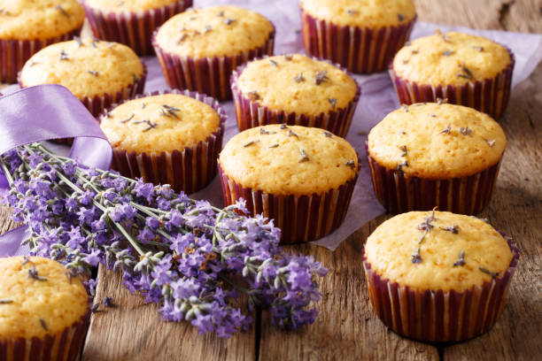 Beautiful background of French muffins with lavender flowers close-up. horizontal Beautiful background of French muffins with lavender flowers close-up on the table. horizontal wedding cake close up macro stock pictures, royalty-free photos & images