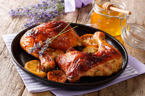 istock French food: fried quarters chicken legs with lavender honey, spices and lemon close-up. horizontal 1063206572