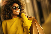 Beautiful mixes race woman holding shopping bags and smiling