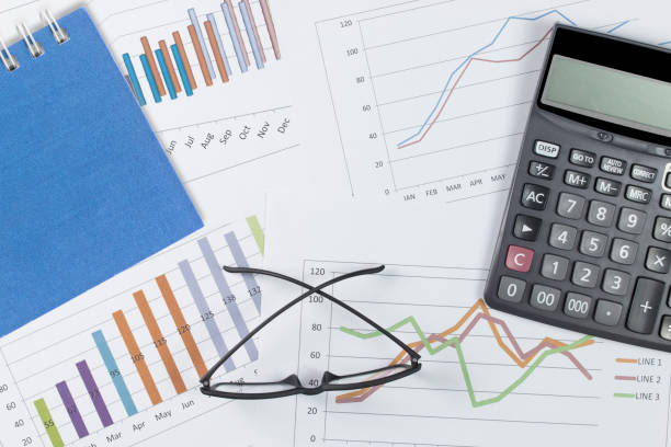 istock business concept : graph with notebook, glasses and calculator on stock market report as background 1063230546