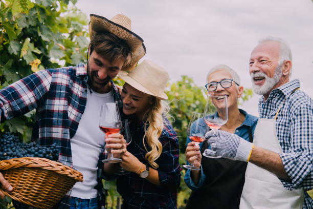 istock Senior and young couples drinking wine in a vineyard 1063236994