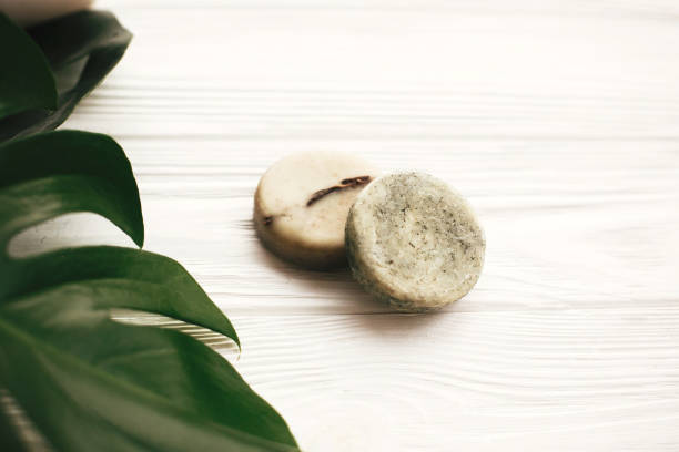 istock Natural eco friendly solid shampoo bar, green conditioner, soap on white wood with green monstera leaves. Eco products plastic free. Hair care and treatment. Zero waste concept. 1063240850