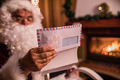 Close up of Santa Claus reading children letters on Christmas eve.