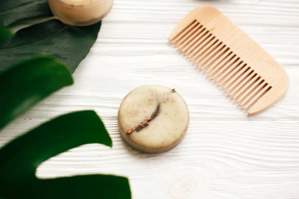 istock Natural eco friendly solid shampoo bar, wooden brush,  conditioner,soap, deodorant cream on white wood with green monstera leaves.  Eco products plastic free. Zero waste concept. 1063242012