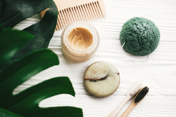 istock Eco friendly natural bamboo toothbrushes, shampoo bar, toothpaste in glass, wooden brush and konjaku sponge on white wood with green monstera leaves. Zero waste concept, plastic free 1063242510