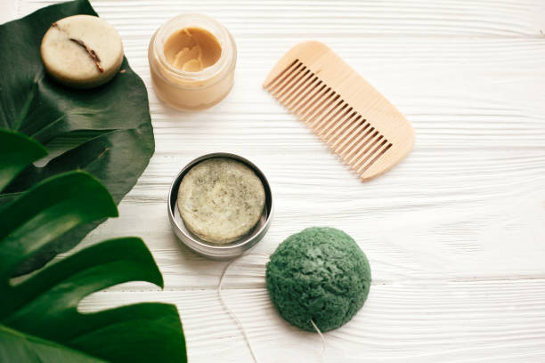 istock Natural eco friendly solid shampoo bar, wooden brush,  conditioner,soap, konjaku sponge on white wood with green monstera leaves. Zero waste products plastic free 1063242514