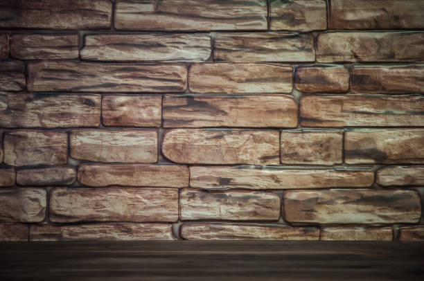 istock Background of a brick wall with a wooden table lit by light. 1063244172