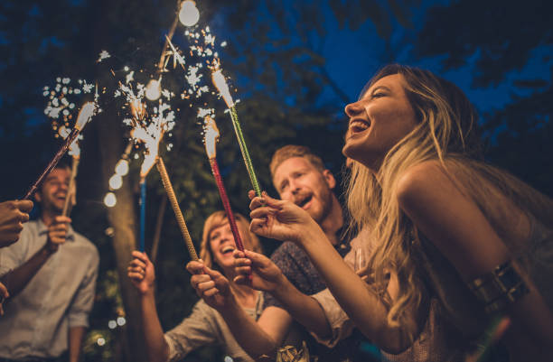istock Cheerful friends having fun while using torches on a night party outdoors. 1063244470