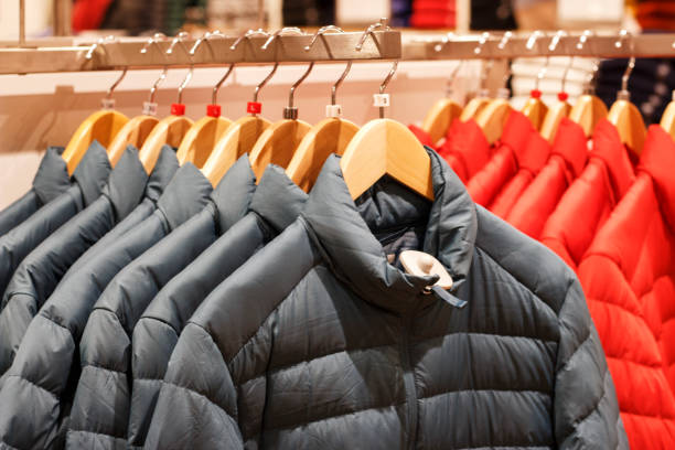 winter jackets on a hanger in the store close-up - bedding merchandise market textile imagens e fotografias de stock