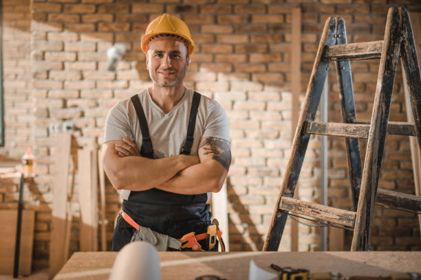 istock Happy manual worker with crossed arms at construction site. 1063248804