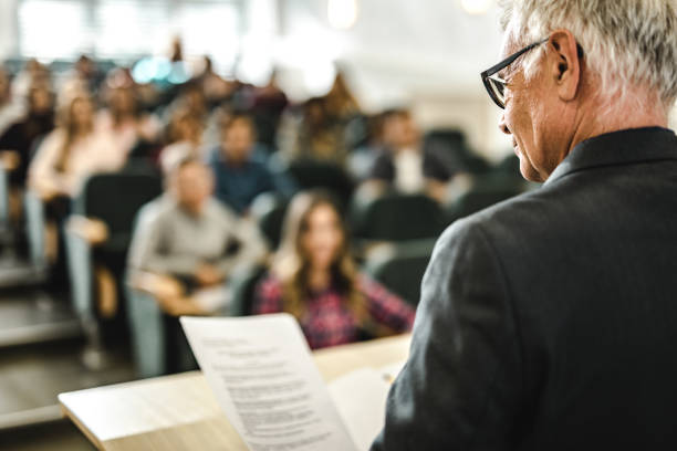 istock Mature professor reading a lecture on a class at lecture hall. 1063253076