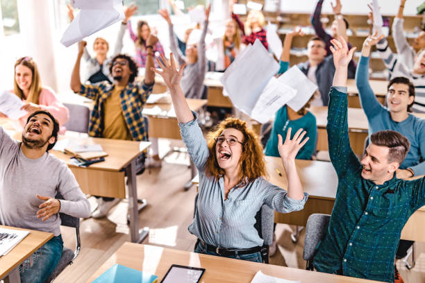 istock Large group of cheerful students having fun while celebrating the end of a class in the classroom. 1063253140